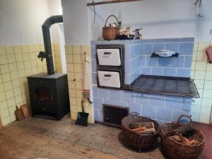 a blue tiled kitchen with a stove and baskets at Chalupa u Josefa in Valašská Polanka +11 photos