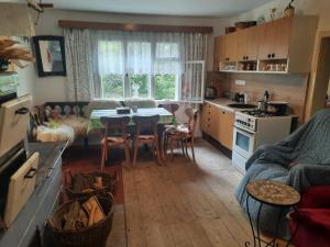 a kitchen and living room with a table and chairs at Chalupa u Josefa in Valašská Polanka