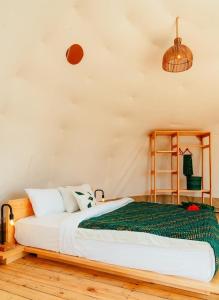 een slaapkamer met een bed met een groene deken bij Rafiki Retreat in Arusha