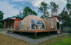 een grote koepeltent op een terras naast een huis bij Rafiki Retreat in Arusha