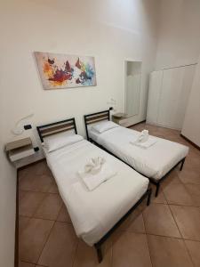 twee bedden in een kamer met een schilderij aan de muur bij Affittacamere Italia Leonardo in Rho