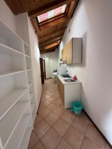 een keuken met witte kasten en een dakraam bij Affittacamere Italia Leonardo in Rho