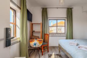 een slaapkamer met een bed, een stoel en een raam bij Aquedarte in Lissabon