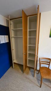 un armadio con una porta di legno e una sedia di legno di Unterkunft Zwisa a Jenaz