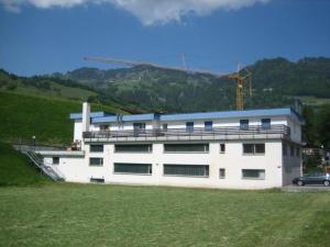 un edificio bianco con una gru sopra. di Unterkunft Zwisa a Jenaz