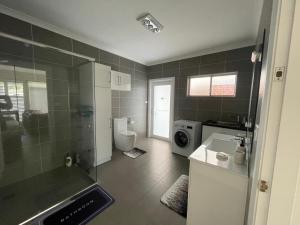 een badkamer met een douche, een toilet en een wastafel bij Serene Guest House in Callala Beach