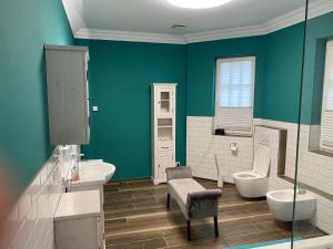 La salle de bains est pourvue de 2 toilettes et d'un mur vert. dans l'établissement Eifel Hills, à Niederdürenbach 19 autres photos