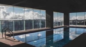 a large swimming pool in a building with windows at The Plaza Lodge Baguio in Camp John Hay