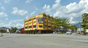 タイピンにあるSuper OYO Capital O 90659 Raintown Timbers Hotelの通り沿いにある黄色い建物