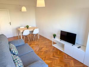 een woonkamer met een bank en een flatscreen-tv bij Velasco Urban Lodge - Turistea in Huesca