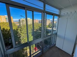 een kamer met grote ramen met uitzicht op de stad bij Velasco Urban Lodge - Turistea in Huesca