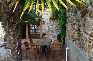 uma mesa de madeira e cadeiras em frente a um edifício em la Maison d'Odette et Daniel em Vitrac