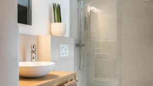 a bathroom with a sink and a shower with a glass door at das MOOSWALD in Obsteig