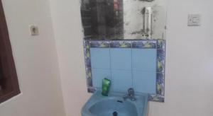 Un baño con un lavabo azul y un espejo. en Hotel O Endj Walet Samodra, en Tepus