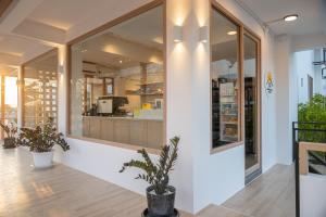 a store front with large windows and a potted plant at Morning Place in Ban Krathum Lom
