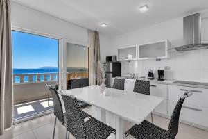 a kitchen with a table and chairs with a view of the ocean at Villa Jasna - Makarska Exklusiv in Tučepi