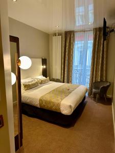 a hotel room with a bed and a window at Best Western Empire Elysees in Paris +90 photos
