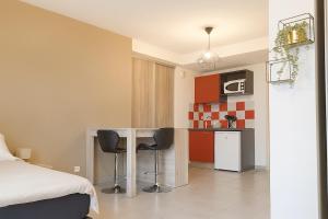 a small kitchen with a table and two chairs in a room at Pleasant, cozy studio with pool 2 mins from Montpellier in Juvignac
