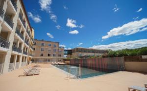 a swimming pool in a courtyard of a building at Pleasant, cozy studio with pool 2 mins from Montpellier in Juvignac