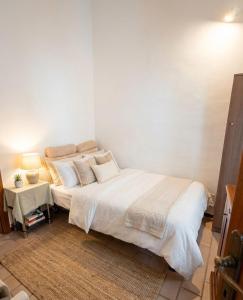 een witte slaapkamer met een bed en een tafel bij Casa Panorama Viterbo Senza ZTL e Parcheggio Gratuito in Viterbo +44 foto's
