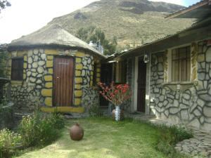ein Haus mit einer Blumenvase davor in der Unterkunft Samana Wasi in Yanque
