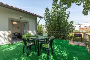 eine Terrasse mit einem Tisch und Stühlen auf dem Rasen in der Unterkunft Carvalhosa Apartment in Monte