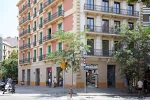 バルセロナにあるアパート スイート オステンプロの市道のピンクと黄色の建物