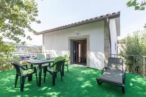 a patio with a table and chairs on the grass at Carvalhosa Apartment in Monte