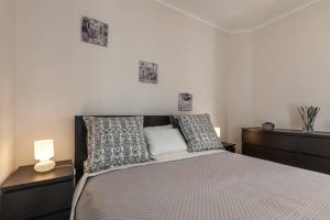 ein Schlafzimmer mit einem Bett mit Kissen und zwei Lampen in der Unterkunft Carvalhosa Apartment in Monte