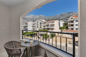 a balcony with a table and chairs and a view at Villa Jasna - Makarska Exklusiv in Tučepi