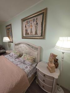 een slaapkamer met een bed en een tafel met een lamp bij House Hotel Apartments 2 in Rivne