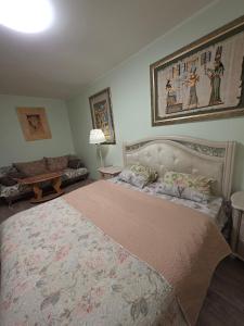 een slaapkamer met een groot bed en een bank bij House Hotel Apartments 2 in Rivne