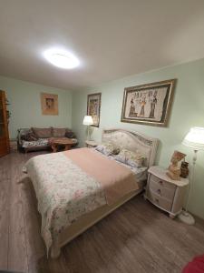 een slaapkamer met een bed en een bank bij House Hotel Apartments 2 in Rivne +1 foto