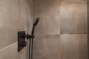 e bagno con doccia con soffione nero. di Egerner Chalet a Rottach-Egern
