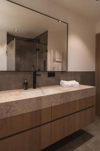 un bagno con un lavandino e un grande specchio di Egerner Chalet a Rottach-Egern