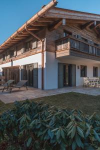 una casa con tetto in legno e patio di Egerner Chalet a Rottach-Egern