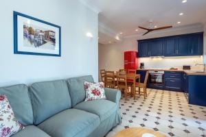 a living room with a couch and a kitchen at Nancy Luxury Suites in Kassiopi