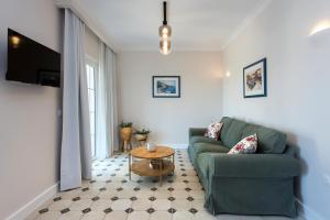 a living room with a green couch and a table at Nancy Luxury Suites in Kassiopi