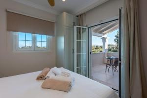 a bedroom with a bed with towels on it at Nancy Luxury Suites in Kassiopi +50 photos
