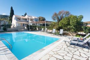 a villa with a swimming pool and a house at Nancy Luxury Suites in Kassiopi