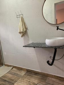 a bathroom with a sink and a mirror at Pousada Mariana in Holambra