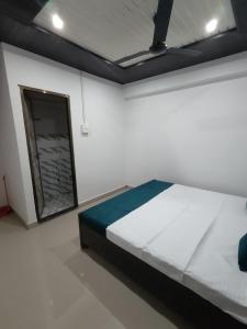 ein Schlafzimmer mit einem Bett in einem weißen Raum in der Unterkunft The Ganga View Home stay in Rāmnagar