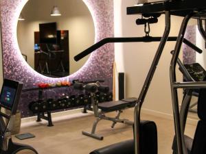 een kamer met een fitnessruimte met een spiegel bij Hôtel Bel Ami in Parijs