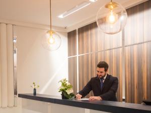 Een man in een pak die aan een bureau zit. bij Hôtel Bel Ami in Parijs +77 foto's