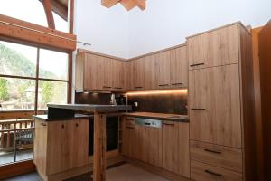 a kitchen with wooden cabinets and a large window at Apartment Zugspitze in Biberwier +16 photos