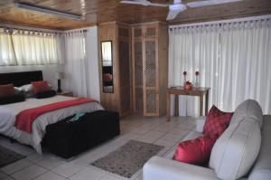 a bedroom with a bed and a couch at TussenIn in Eersterivierstrand