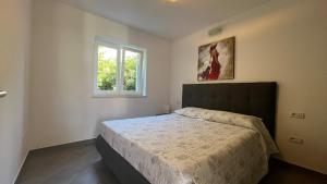 una camera da letto con un letto e una finestra di SeaHouse 114 a Mali Lošinj (Lussinpiccolo)