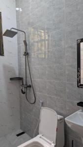 a bathroom with a shower with a toilet and a sink at Danshome in Moshi +7 photos