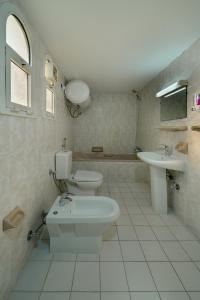 阿布扎比Lunar Beach Hostel的配有两个水槽、一个马桶和一个浴缸的浴室