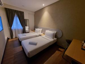 ein Hotelzimmer mit zwei Betten und einem Fernseher in der Unterkunft Miico Hotel Permas Jaya in Johor Bahru + 135 Fotos